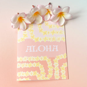 Yellow plumeria lei greeting card next to four plumeria floweres